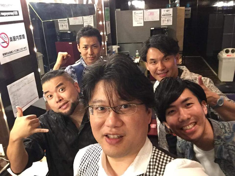 楽屋で記念撮影するサポートバンドの5人